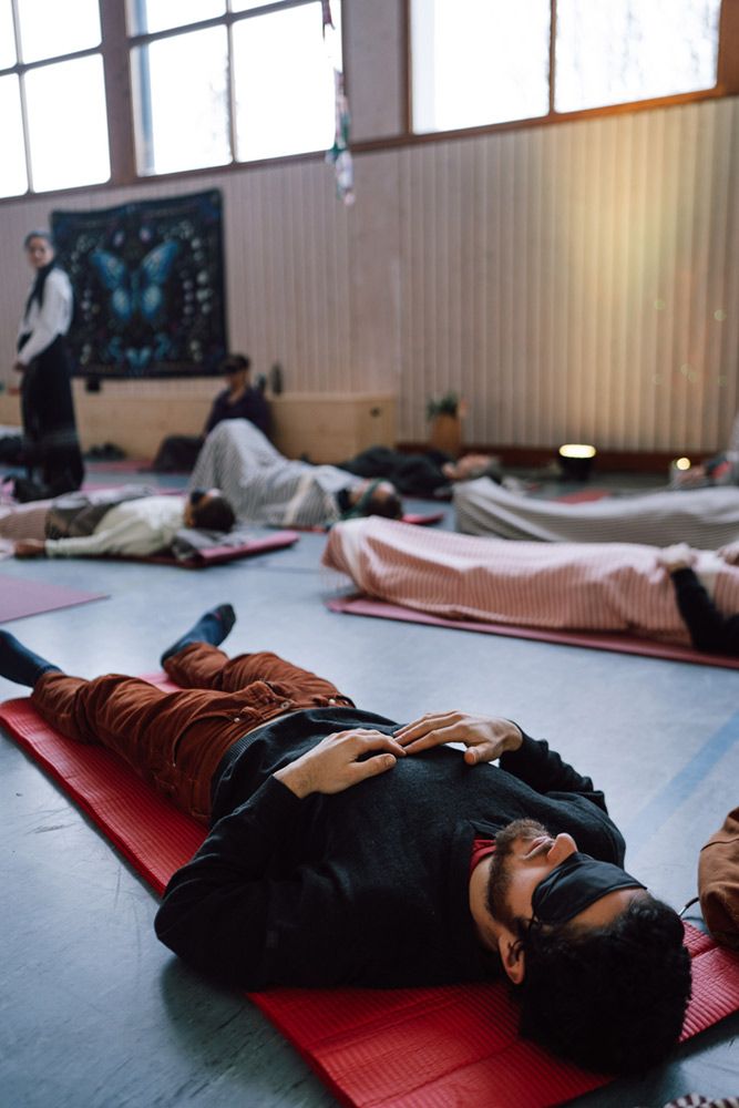 Ein Teilnehmer liegt beim Breathwork mit Augenbinde auf der Matte, die Hände auf der Brust, während einer Atemreise